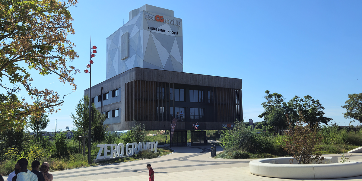 Le bâtiment "Zero Gravity", au design moderne et contrasté, avec une signalétique marquante et un environnement paysager accueillant pour les visiteurs.